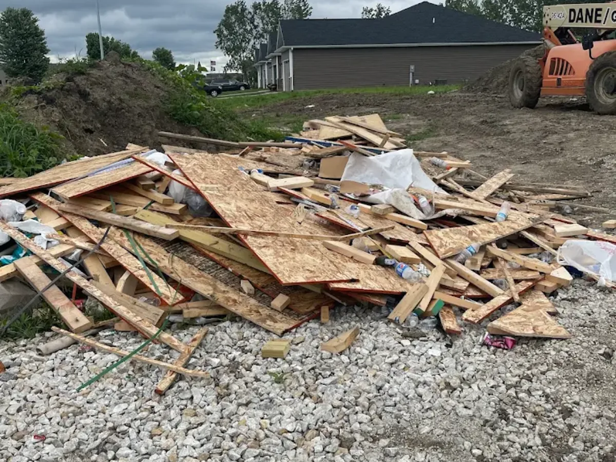 Lumber and plywood debris pile at a construction site