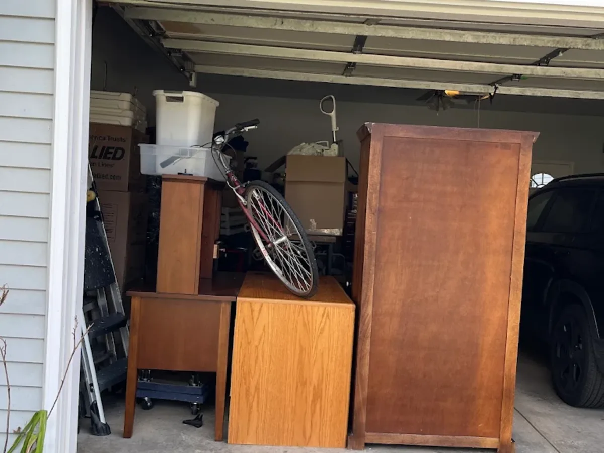 Garage cleanout with wood cabinets, dresser and a bike