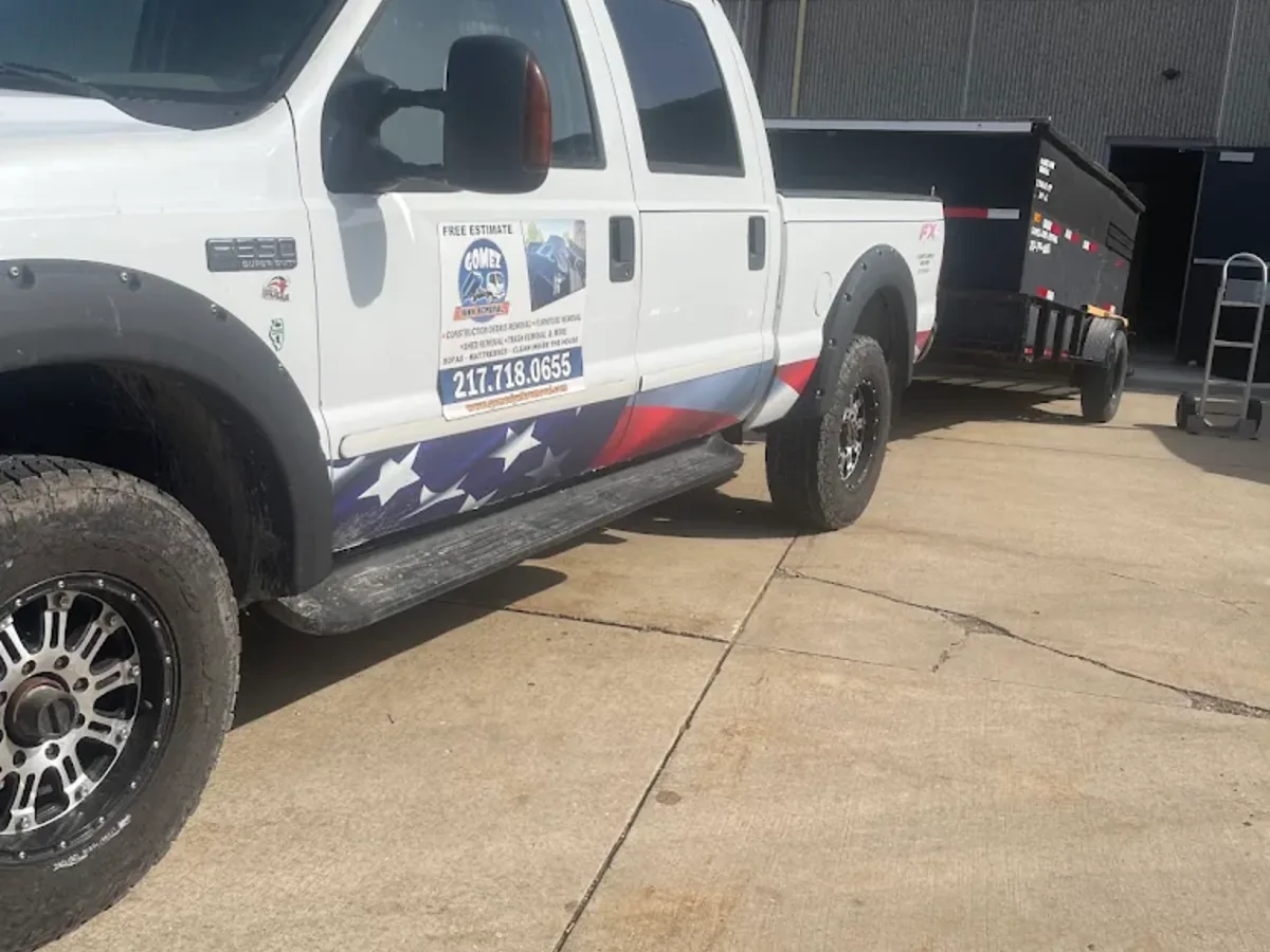Junk removal truck with a dump trailer parked on a Springfield driveway